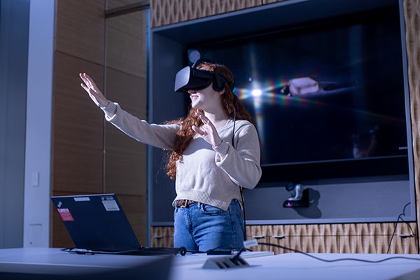 Woman wears virtual reality headset.