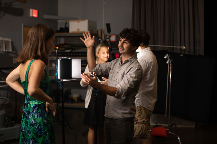 Instructor talks to a student in a studio environment.