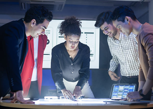 Group standing around a desk.