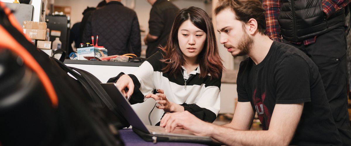 A man and woman looking at a laptop screen